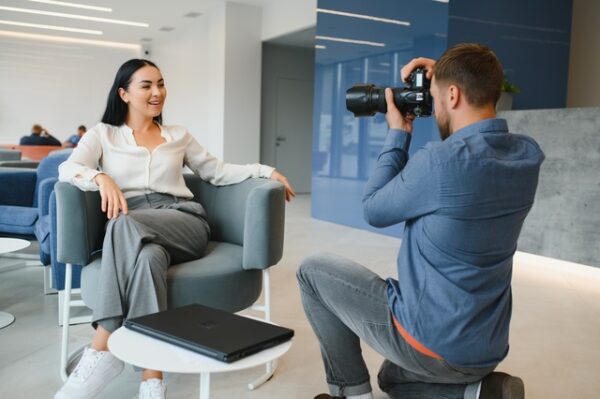 Male photographer taking picture of young woman