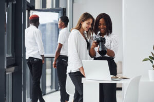 Woman testing camera. Group of african american business people working in office together